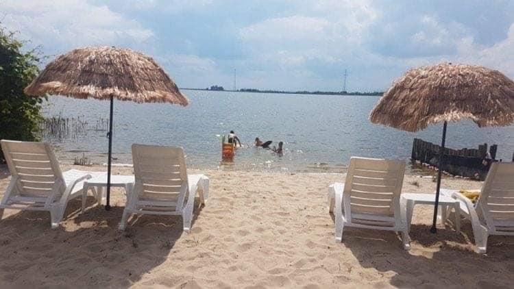 a group of chairs and umbrellas on a beach at Lawendowa Przystań WICKO 3 km od Międzyzdrojów in Międzyzdroje