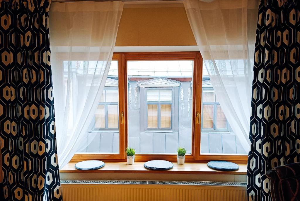 a window with two plates on a window sill at Elegant Old Town Toffee Bliss Apartment, SELF Check-In, Steps from Bus Station in Riga