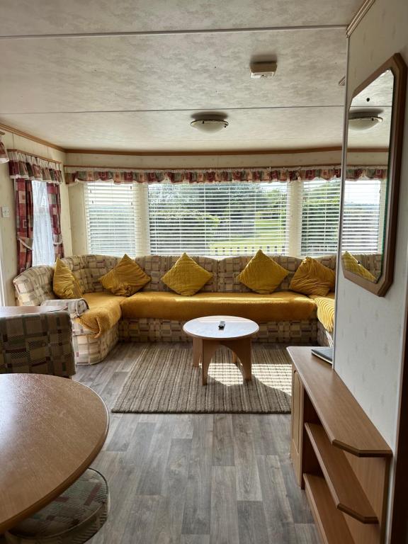 a living room with a couch and a table at Static Caravan in Pwllheli