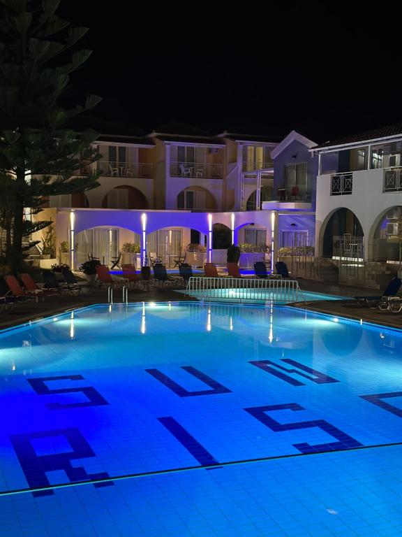 a large swimming pool in front of a building at night at Sunrise Zante - Adults Only Hotel in Tsilivi