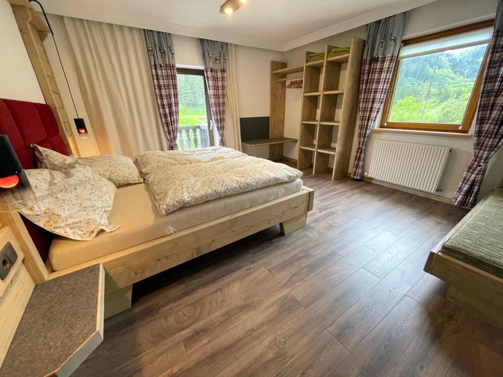 sypialnia z łóżkiem, biurkiem i oknami w obiekcie Ferienwohnung Lisal w mieście Mutters