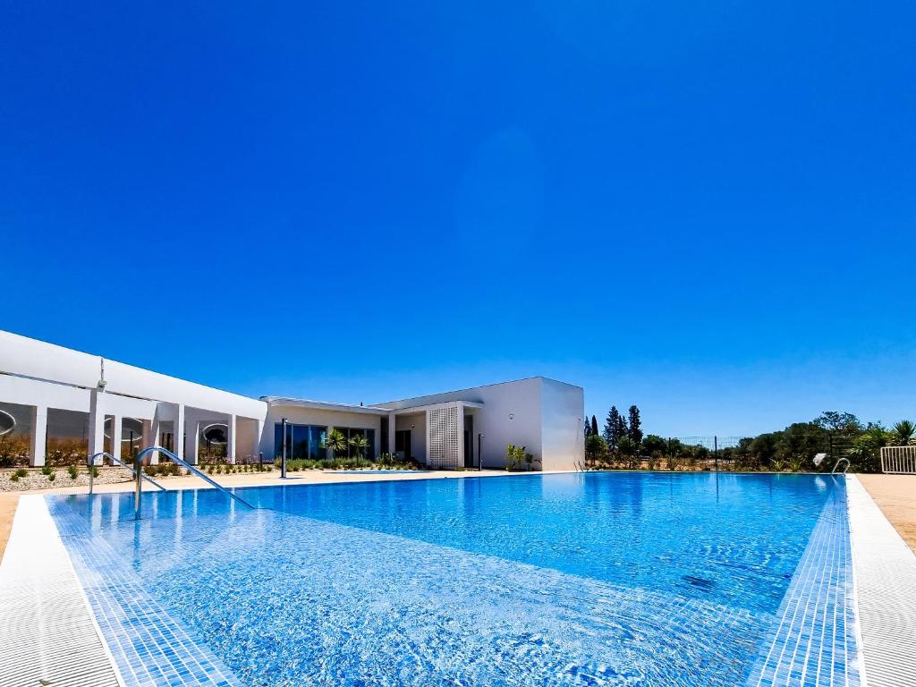 a large swimming pool in front of a building at FLH Vilamoura Duplex with Terrace & Pool in Vilamoura