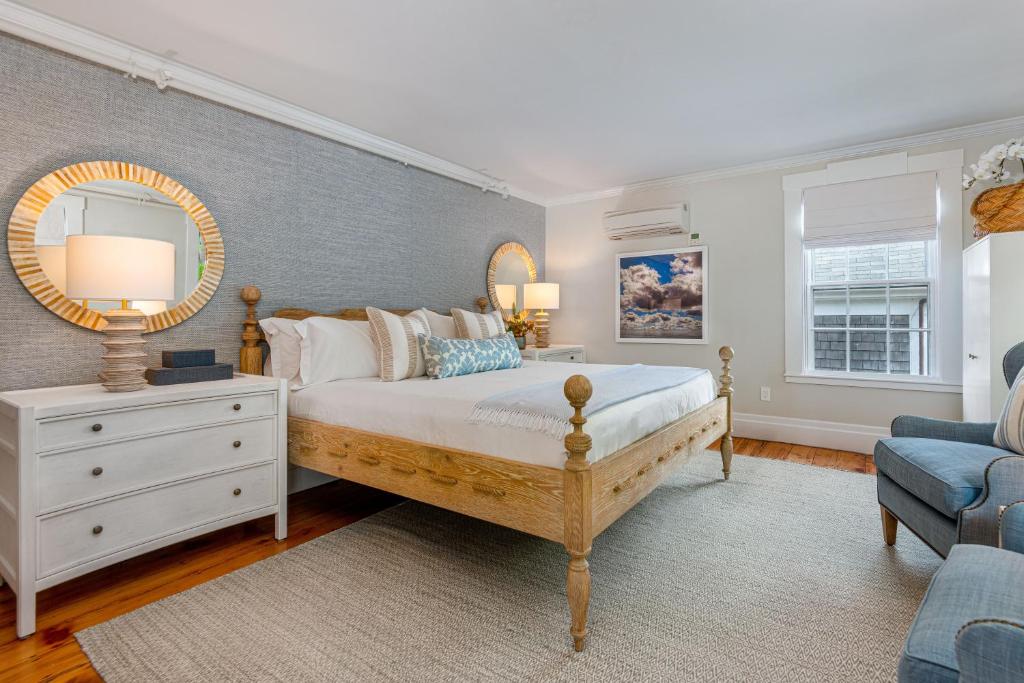 a bedroom with a large bed and a mirror at Nantucket Periwinkle in Nantucket
