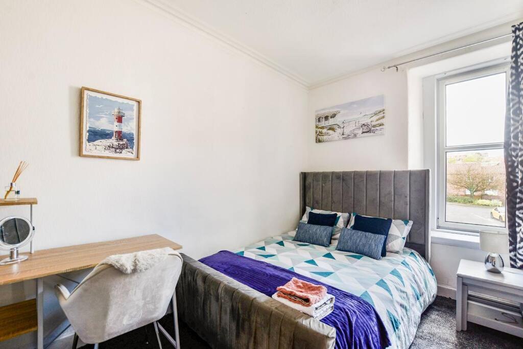 a bedroom with a bed and a desk and a window at Tiny home at Dundee in Dundee