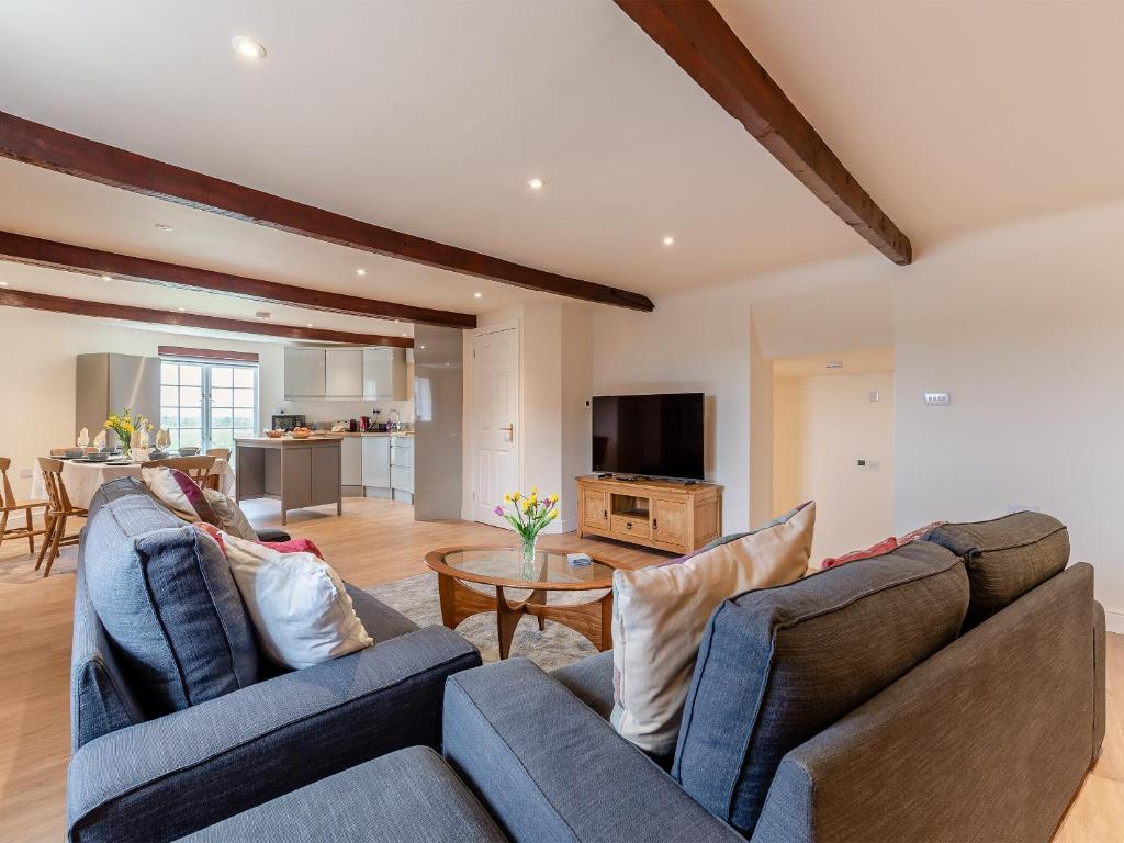 una sala de estar con 2 sofás azules y una mesa. en Oast View - Uk43088, en Preston