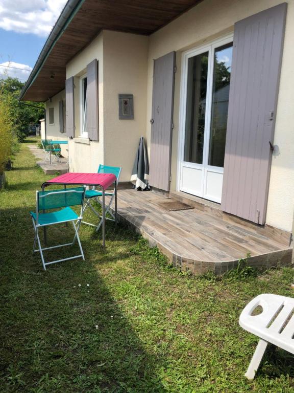 a deck with a table and chairs in front of a house at Charmant séjour à Andernos in Andernos-les-Bains