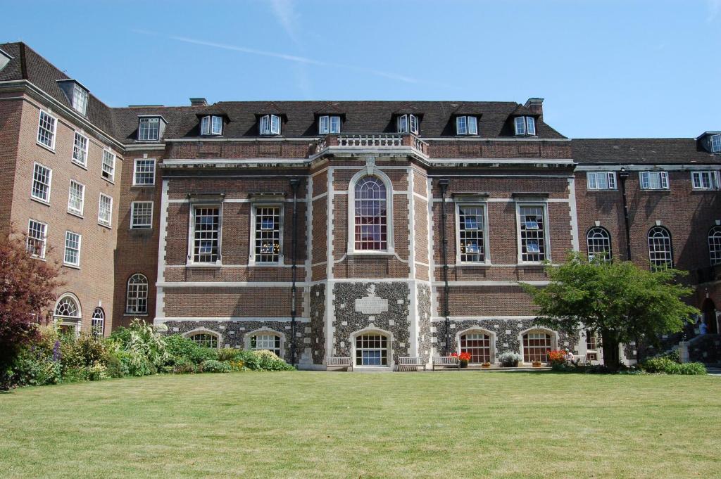 ein großes Backsteingebäude mit einem großen Rasen davor in der Unterkunft Goodenough College – University Residence in London