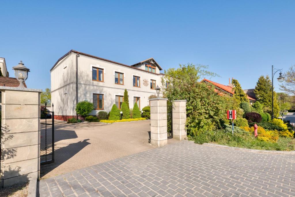 a white house with a gate and a driveway at Dom & House - Apartamenty Nautilus Jelitkowo 50 metrów od plaży in Gdańsk