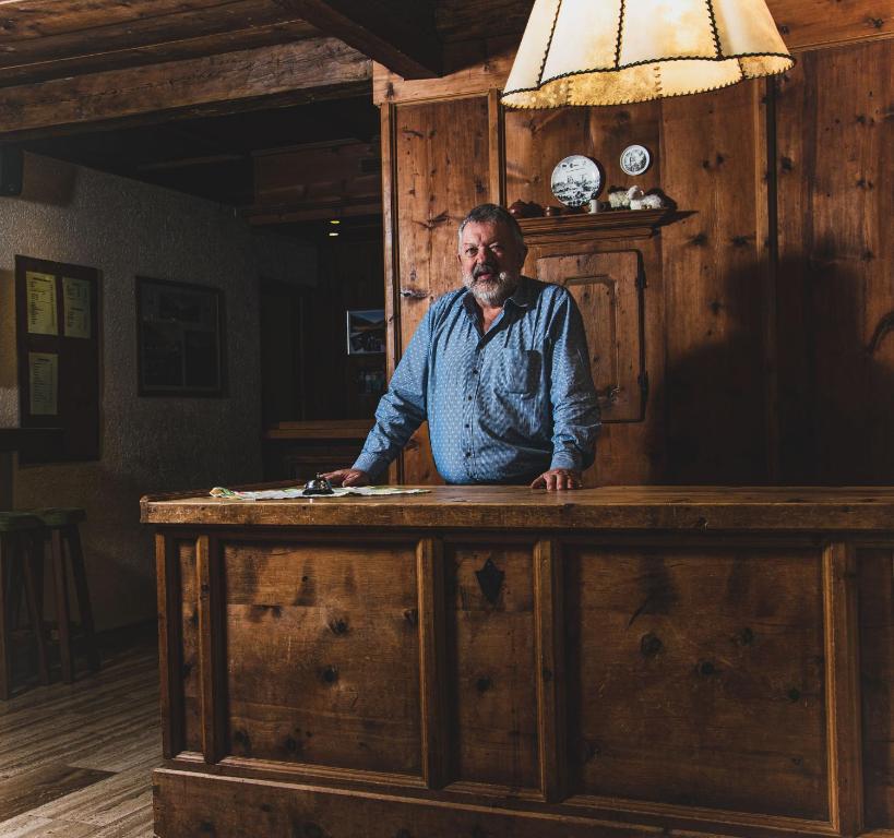 a man sitting at a wooden desk in a room at Hotel Marko in Oetz