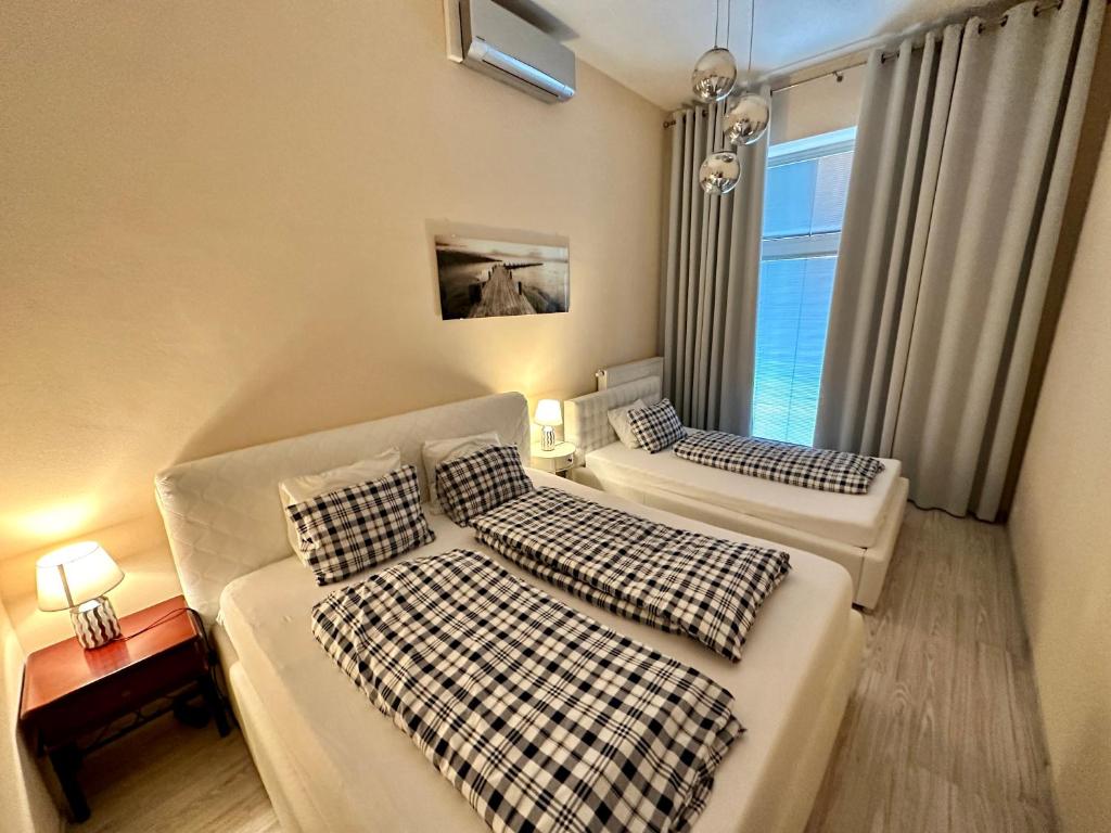 a bedroom with two beds and a couch and a window at Princess City Centre Apartment in Poprad
