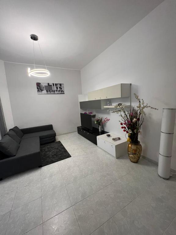 uma sala de estar com um sofá preto e uma televisão em Port House em Civitavecchia