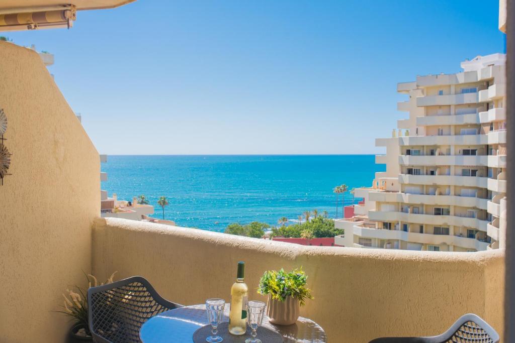 un tavolo su un balcone con vista sull'oceano di Espectacular apartamento. a Benalmádena