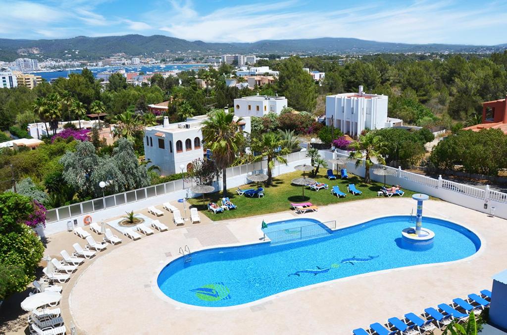 einen Luftblick auf einen Pool mit Stühlen und ein Resort in der Unterkunft Hotel Apartamentos Vibra Monterrey in Bucht von San Antonio