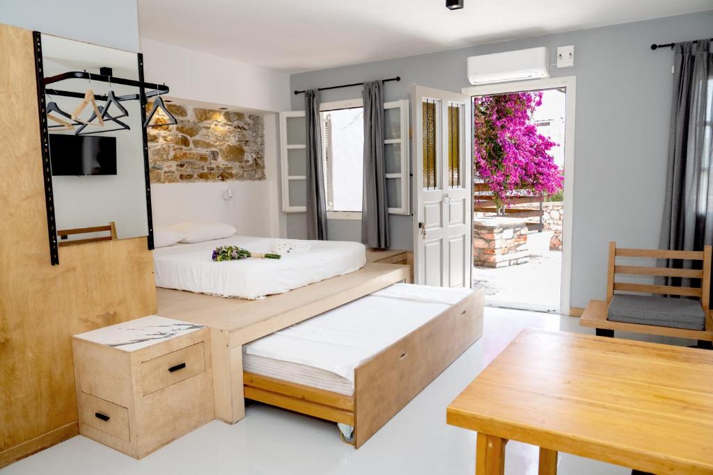 una camera con due letti e un tavolo di Axilleion Guest House a Ermoupoli