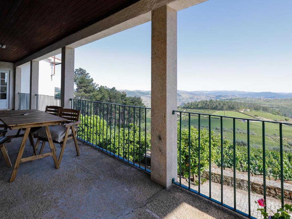 een balkon met een tafel en uitzicht op de bergen bij Quinta Soutelinho in Sabrosa
