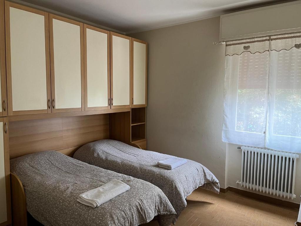 um quarto com 2 camas e uma janela em Home Primavera em Desenzano del Garda