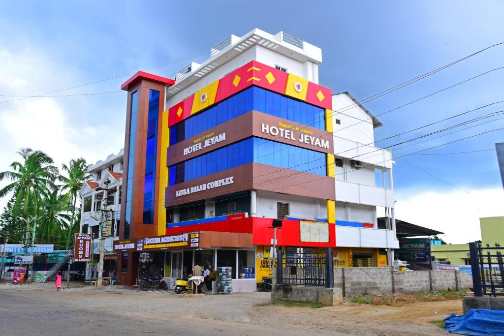 een hotel met een kleurrijk gebouw in een straat bij Hotel Jeyam in Kanyakumari