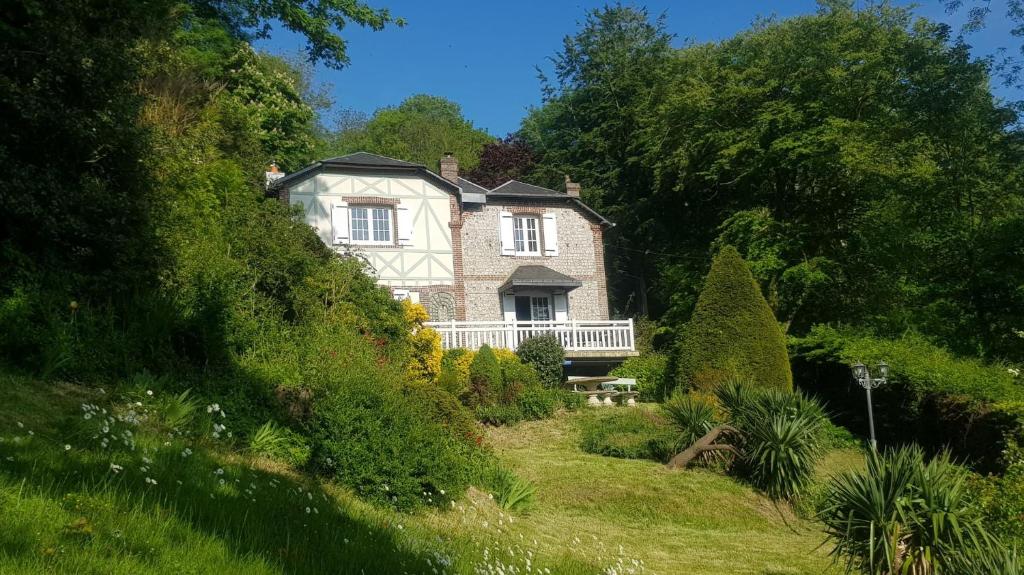 a house on the side of a hill with trees at Villa Colin, la tête dans les bois, à deux pas de la mer, classée 4 étoiles in Yport