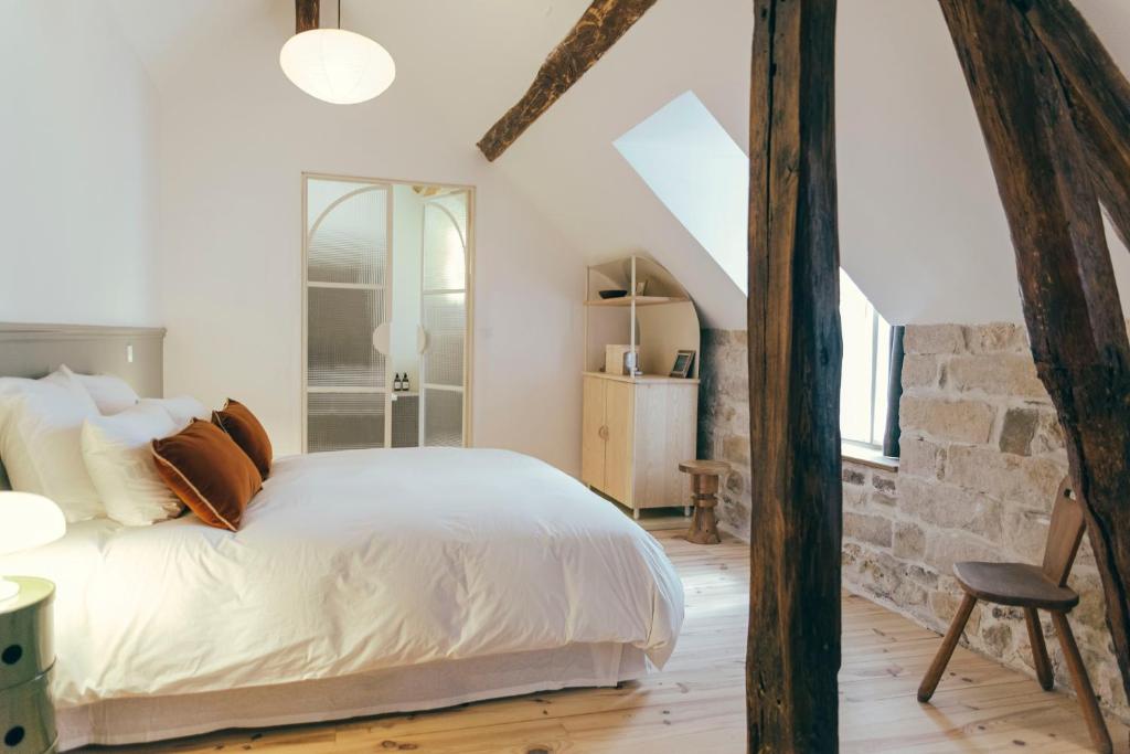 um quarto com uma cama e uma parede de pedra em La Papote em Bourron-Marlotte