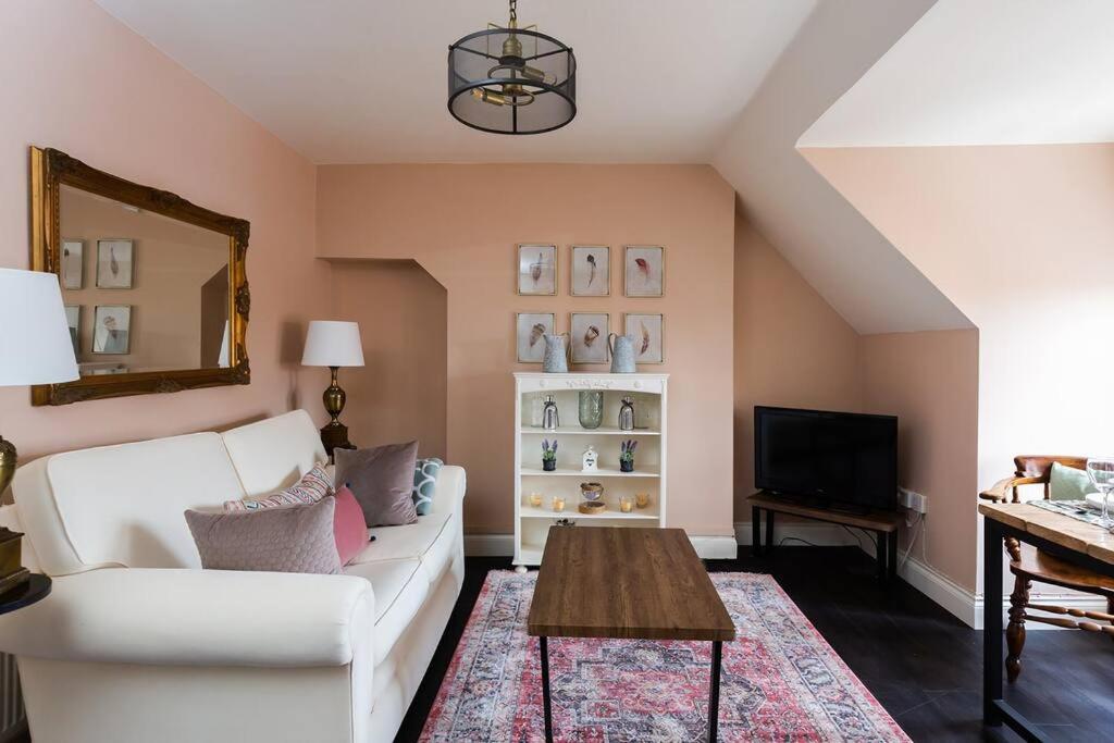 a living room with a white couch and a table at Queenie - Charming one bedroom apartment in quiet location in Kent