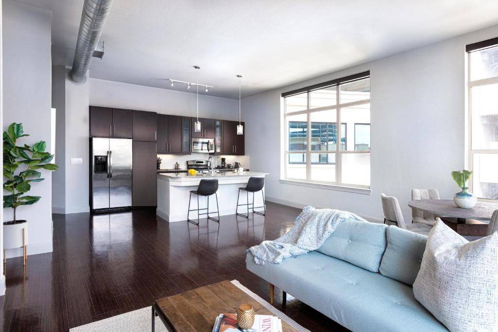 a living room and kitchen with a blue couch at Locale at the Galleria - Houston in Houston