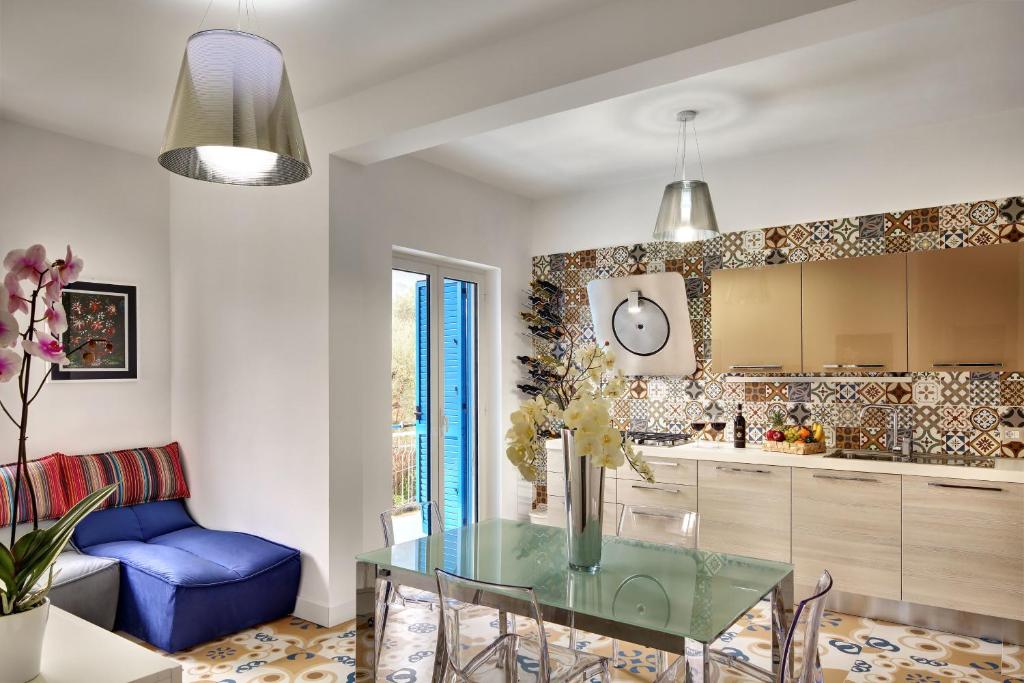 een keuken met een glazen tafel en een blauwe stoel bij Caruso 2 - Sorrento in Sorrento