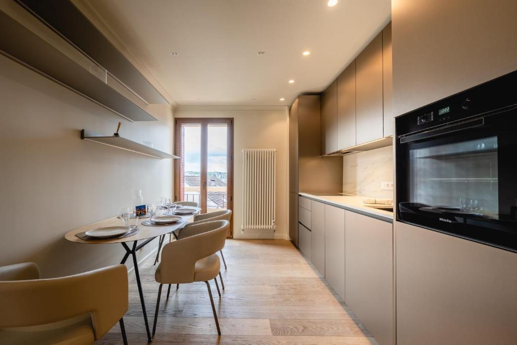 a kitchen with a table and chairs and a microwave at Le Nid du Favre II - Large 2 room with breathtaking view of the lake in Annecy