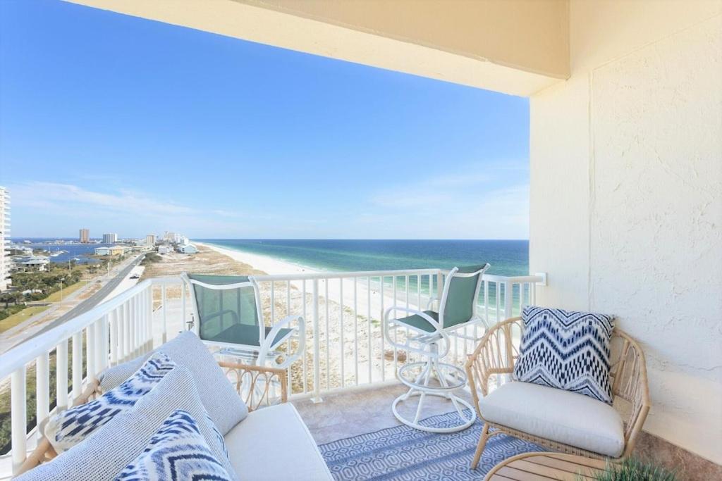a balcony with chairs and a view of the ocean at Ocean Front Penthouse Suite Panoramic Views of Gulf,Pensacola Beach,Pier, & Bay in Pensacola Beach