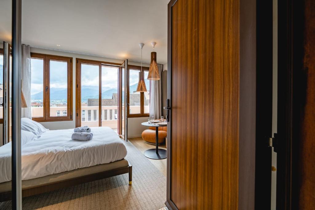 une chambre avec un lit et une grande fenêtre dans l'établissement Le Nid du Favre I - Charming studio with stunning lake view, à Annecy