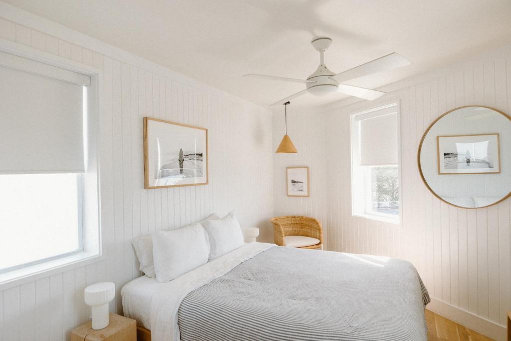 1 dormitorio blanco con 1 cama y ventilador de techo en The Sunsetter by WB Abodes, en Wrightsville Beach