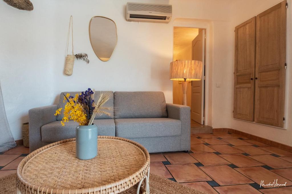 a living room with a couch and a table at Hôtel Palombaggia in Porto-Vecchio