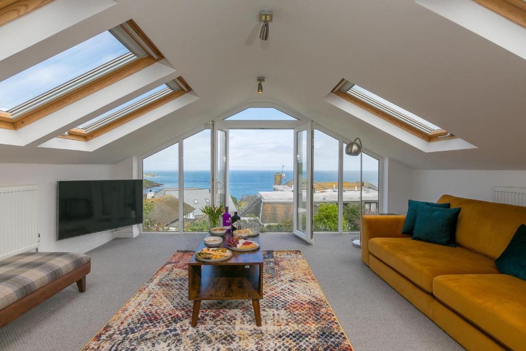 a living room with a couch and a tv at Ocean Air in Carbis Bay