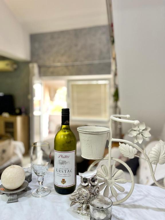 a bottle of wine sitting on a table with glasses at Apartman Guberinic,Tivat ,trosoban stan in Tivat