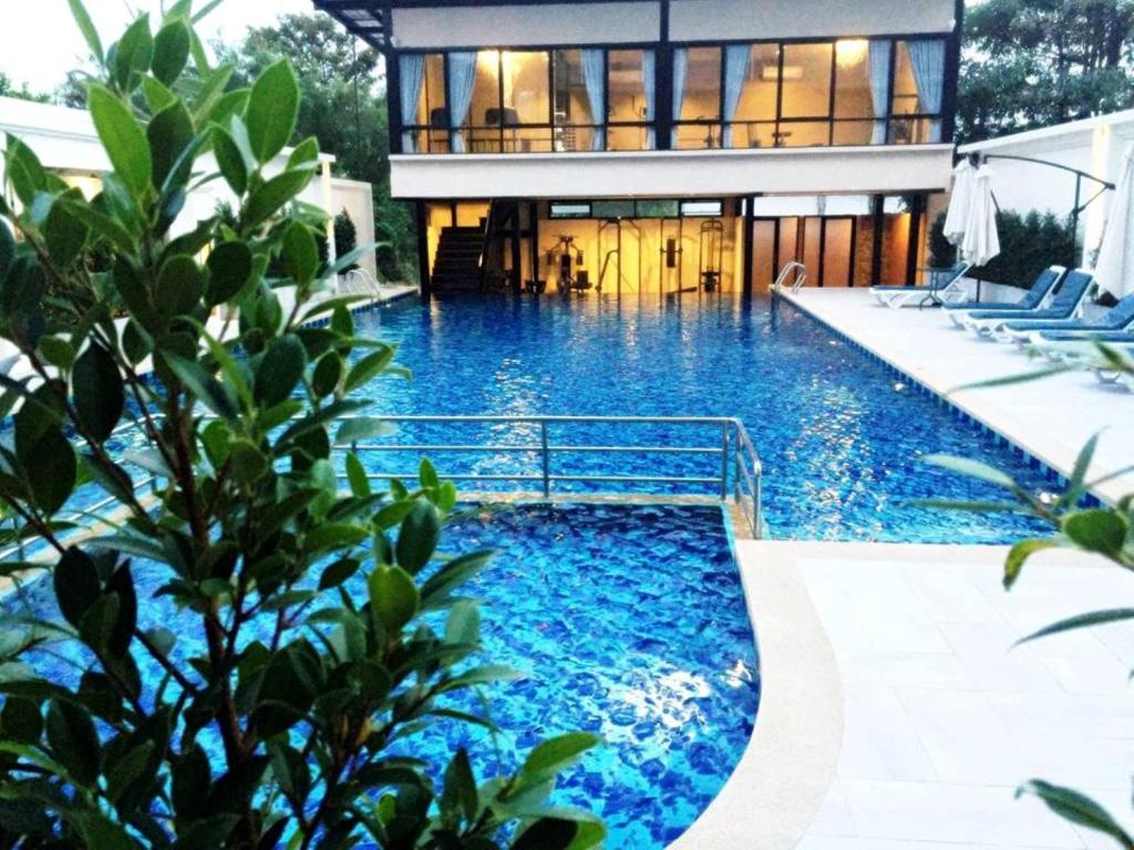 a house with a swimming pool in front of a house at Avana Laem Chabang Boutique Hotel in Ban Laem Chabang