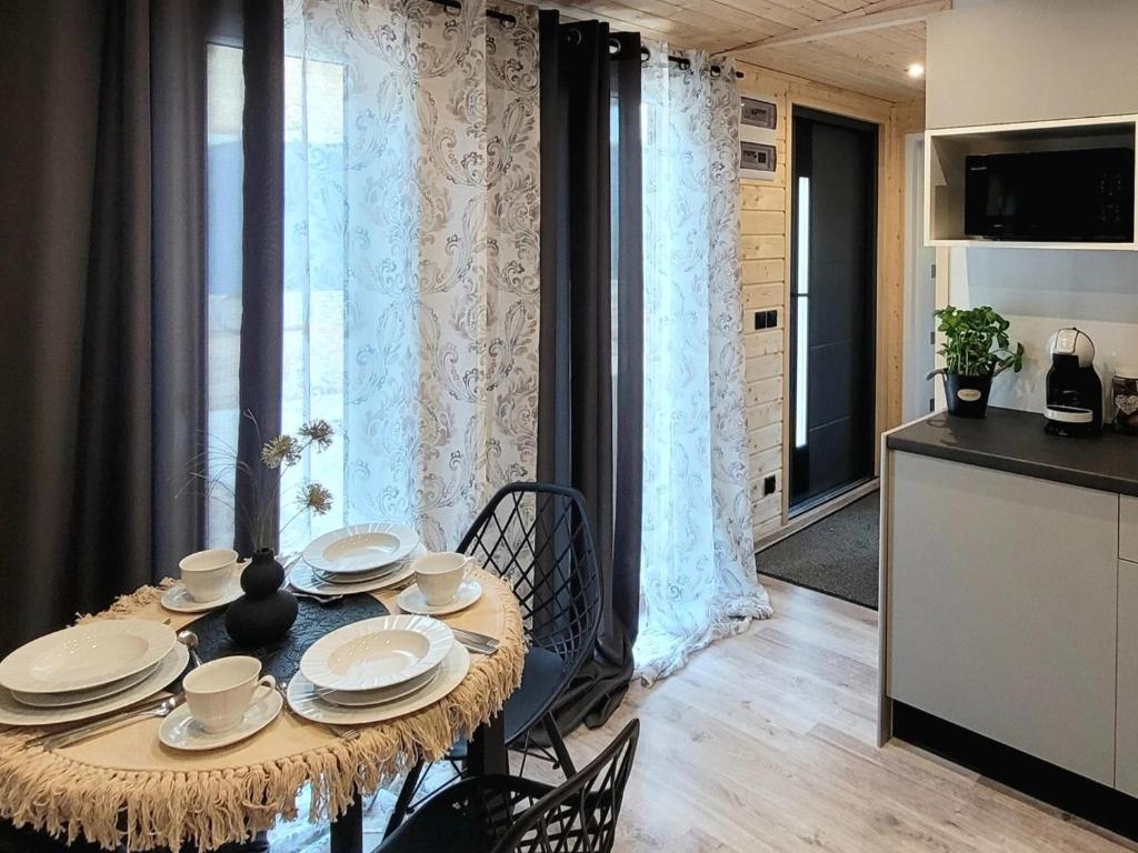 a dining room with a table with dishes on it at DomEK Obok Rzeki in Bałtów