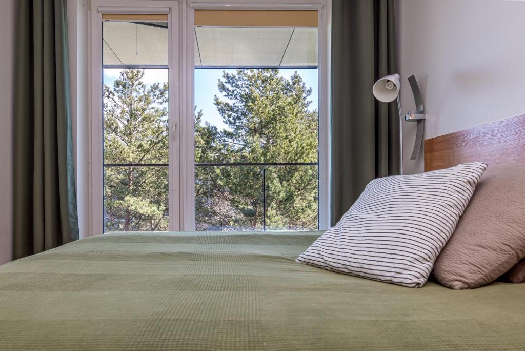 sypialnia z łóżkiem i dużym oknem w obiekcie Nature - Vanagupės apartamentai w Połądze