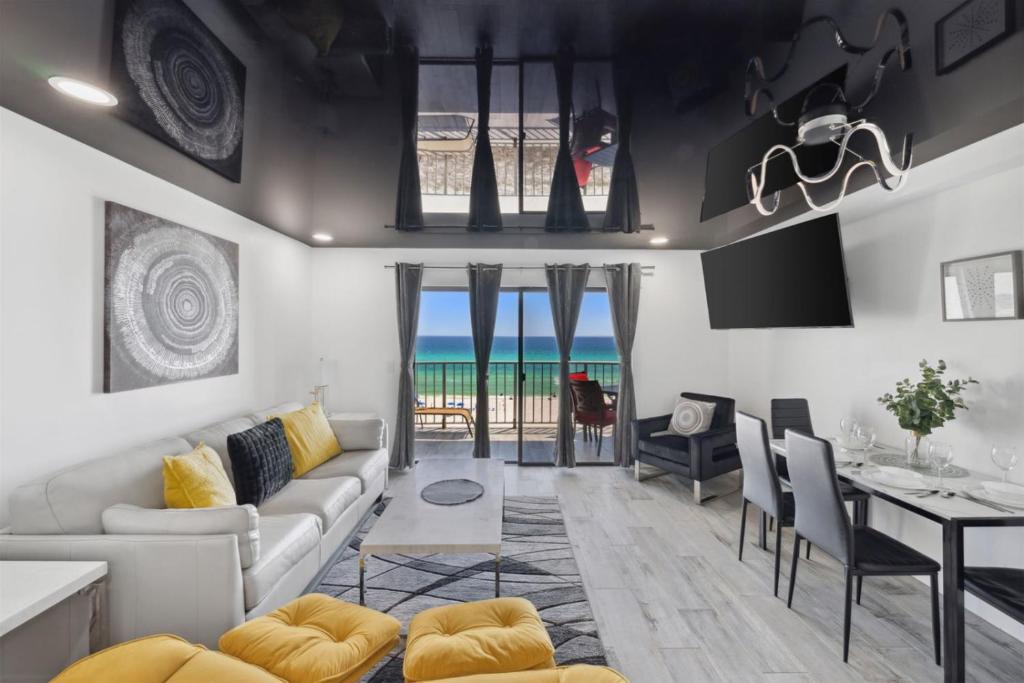 a living room with a couch and a table with chairs at The Summit 702 in Panama City Beach