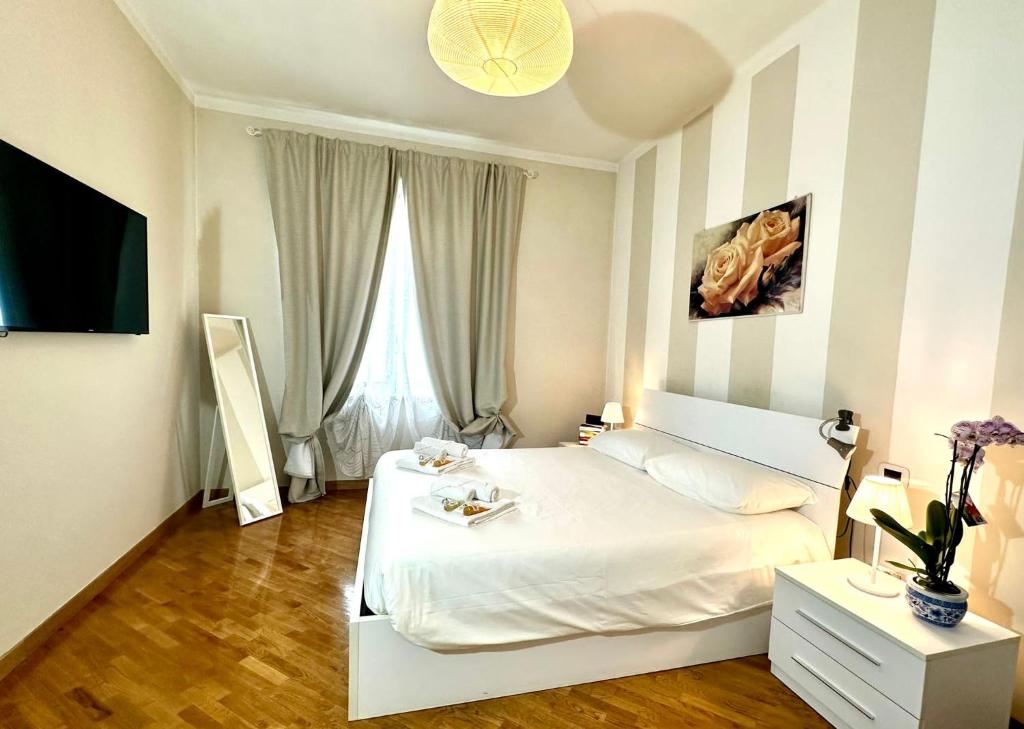 a bedroom with a white bed and a window at Lovely Lucca [free parking] in Lucca