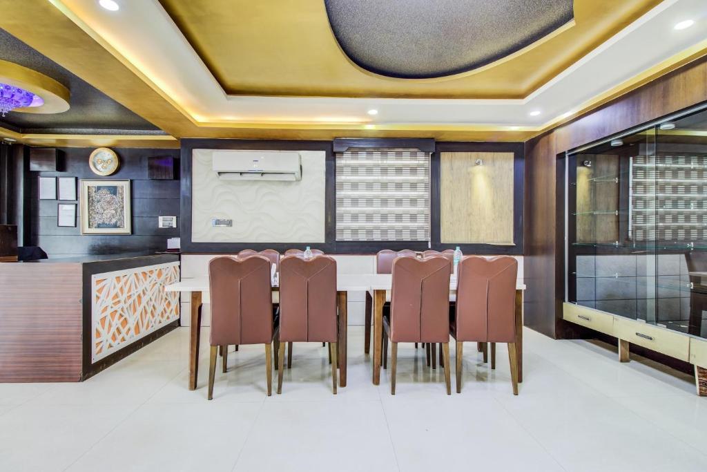 a dining room with a table and chairs at Capital O 5381 The Emirates Hotel in Bangalore