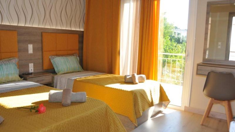 a hotel room with two beds and a window at Senia Holidays in Preveza