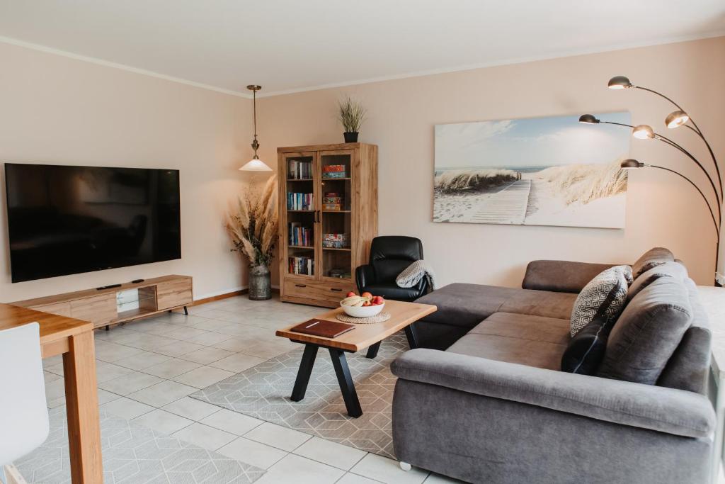 a living room with a couch and a tv at Stylisches modernes Apartment, Sauna und Wellness Top Lage in Lübbecke