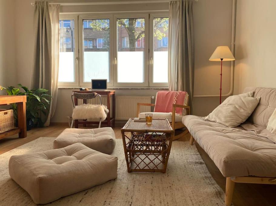 布魯塞爾的住宿－Superbe appartement avec jardin, sauna et jacuzzi，客厅配有沙发和桌子