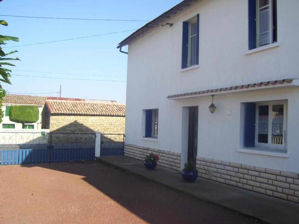 una casa blanca con una valla azul delante de ella en Lovely 4-Bed House in rural West France, en Clussais-la-Pommeraie