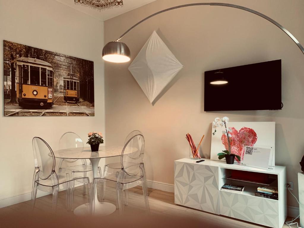 a dining room with a table and chairs and a tv at Scarlatti Luxury apt. - B. Aires / Central Station in Milan