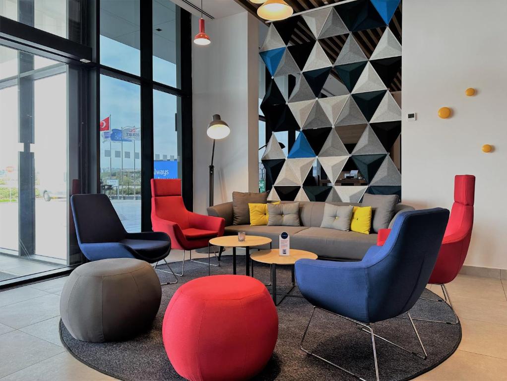a living room with chairs and a couch and tables at Holiday Inn Express - Ankara - Airport by IHG in Ankara