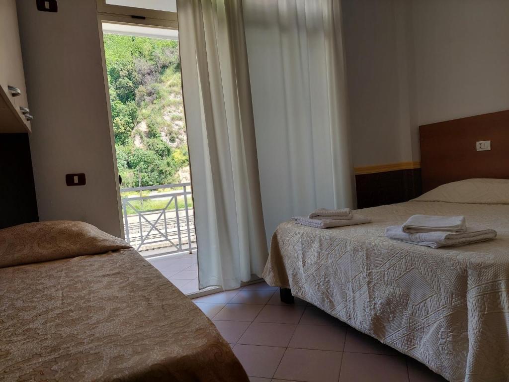 1 dormitorio con 2 camas y ventana grande en Hotel Nacional Durres en Durrës