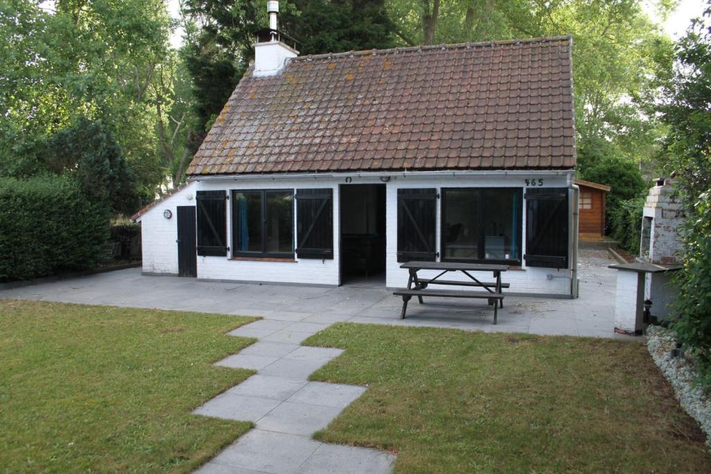 uma casa com uma mesa de piquenique em frente em Bulli Beach House em Koksijde