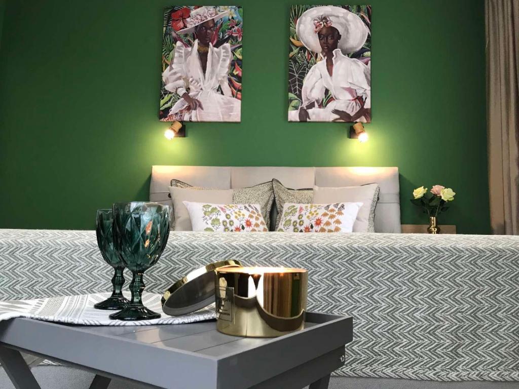 a bedroom with a bed with a green wall at Аpartment Bella Vista in Obzor