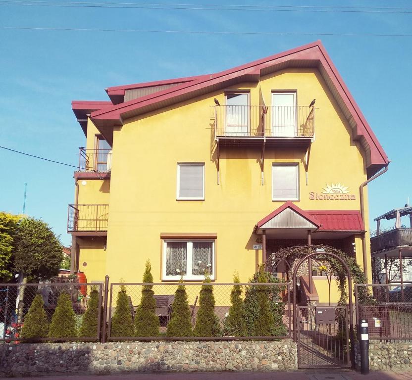 een geel huis met een hek ervoor bij Willa Słoneczna in Władysławowo