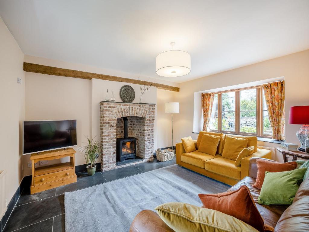 a living room with a couch and a fireplace at Derwen Deg Fawr in Llanfair-Dyffryn-Clwyd